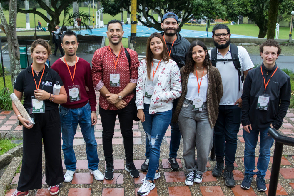 Integrantes de Iberacademy sonriendo a la cámara frente al hogar de señorita 