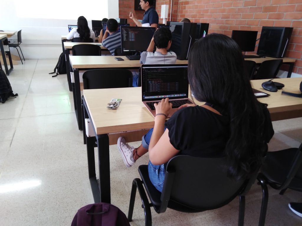 Estudiante del programa de asistente en desarrollo de software, generando sus líneas de código en su computador 